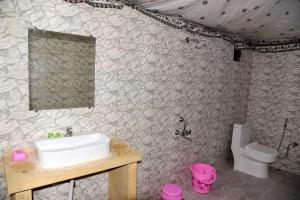 uma casa de banho com um lavatório e um WC em Hilton Jaisalmer Desert camp em Sām