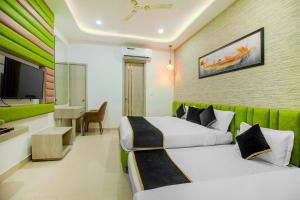 Una habitación de hotel con dos camas y un televisor de pantalla plana. en Hotel Golden Stay, en Amritsar