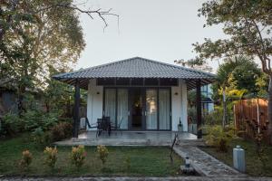 シギリヤにあるNIVADOO RESORT SIGIRIYAの黒屋根の小さな白い家