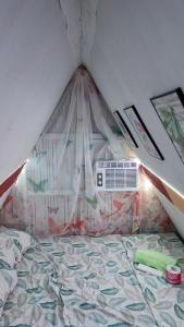a bedroom with a bed with a mosquito net at LABUYO FARM 