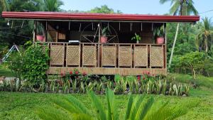 a house with a balcony with flowers and plants at LABUYO FARM 