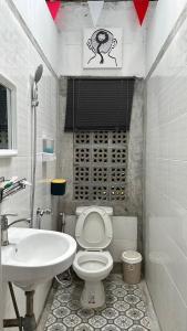 a bathroom with a white toilet and a sink at Fluid PHUKET in Ban Sam Kong