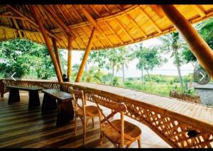 - une terrasse couverte avec 2 chaises, une table et un banc dans l'établissement Tinggian Hill Retreat, à Nusa Penida