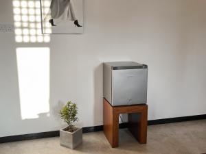 a tv sitting on a table next to a plant at Lum Residence in Ahangama