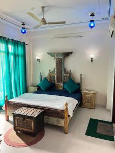 Little Ganesha Inn في جايبور: غرفة نوم بسرير كبير مع وسائد زرقاء