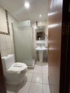 een badkamer met een douche, een toilet en een wastafel bij فندق ضيافة دلة in Jeddah
