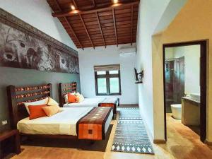 a bedroom with a large bed and a bathroom at Serendib Signature Resort in Digana