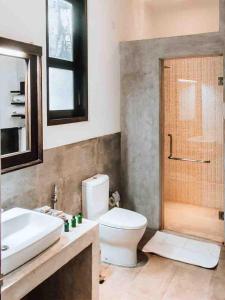 y baño con aseo, lavabo y ducha. en Serendib Signature Resort, en Digana