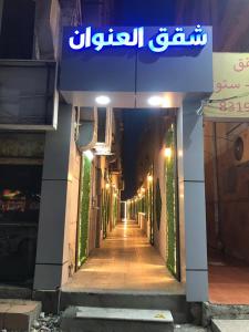 Une allée avec un panneau sur le côté d'un bâtiment dans l'établissement العنوان للوحدات المخدومة ALanwaan of the units served, à Dammam