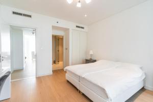 Dormitorio blanco con cama y pasillo en Luxury, 3 bedrooms, Saadiyat Island, spacious, beach & pool, restaurants, gym en Abu Dabi