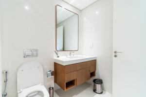 a bathroom with a toilet and a sink and a mirror at Luxury, 3 bedrooms, Saadiyat Island, spacious, beach & pool, restaurants, gym in Abu Dhabi