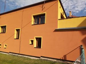 a yellow and orange building with windows at Garsonka u pivovaru, centrum Rožnov in Rožnov pod Radhoštěm
