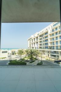 uma vista a partir de uma janela de um grande edifício em Luxury, 3 bedrooms, Saadiyat Island, spacious, beach & pool, restaurants, gym em Abu Dhabi