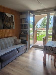 ein Wohnzimmer mit einem Sofa und einem Tisch in der Unterkunft Studio avec jardin et garage, à 100m d'une piste in Les Deux Alpes