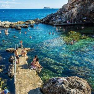 un grupo de personas nadando en el agua en Bizzilla Lodging Suite, en Mqabba