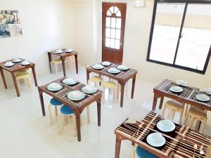 comedor con mesas y sillas de madera en Dy Heritage Suites, en Vigan
