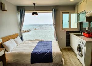 a bedroom with a bed and a view of the ocean at Sometimes Jeju in Jeju