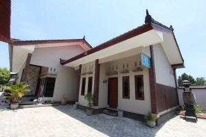 een huis met een binnenplaats ervoor bij OYO Life 93157 Kos Kaloka in Tanjung