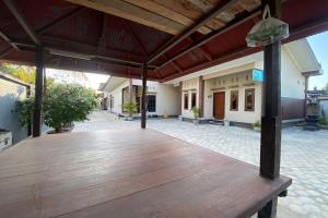 een lege patio met een houten terras bij OYO Life 93157 Kos Kaloka in Tanjung