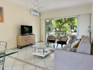 a living room with a couch and a glass table at Spacieux appartement face mer in Menton