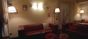a living room with a leather couch and two lights at Cavalieri del Tau in Altopascio