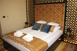 een slaapkamer met een bed met witte lakens en blauwe kussens bij Carpe Diem Boutique Hotel in Zenica