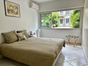 a bedroom with a large bed in a room with a window at Spacieux appartement face mer in Menton