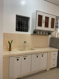 a kitchen with white cabinets and a sink at Ocean and mountain view house in Mabini
