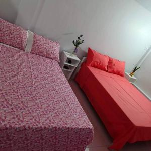 a bedroom with two beds with pink sheets and a bedskirts at Ocean and mountain view house in Mabini