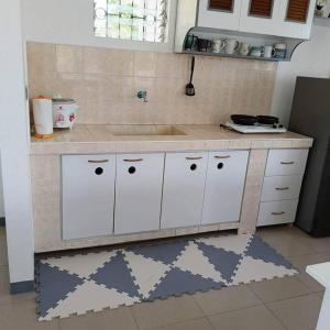 a kitchen with white cabinets and a counter top at Ocean and mountain view house in Mabini