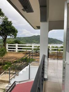 a balcony of a house with a view of a field at Ocean and mountain view house in Mabini