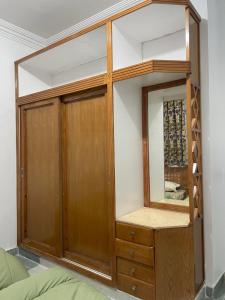 um armário com um armário de madeira e um espelho em A cozy room in 2 bedrooms apartment with a back yard em Sharm el Sheikh
