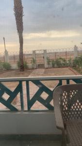 a bench on a balcony with a fence and a palm tree at A cozy room in 2 bedrooms apartment with a back yard in Sharm El Sheikh