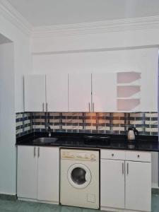 a kitchen with a sink and a washing machine at A cozy room in 2 bedrooms apartment with a back yard in Sharm El Sheikh
