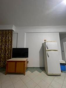 uma cozinha com um frigorífico branco e uma mesa em A cozy room in 2 bedrooms apartment with a back yard em Sharm el Sheikh