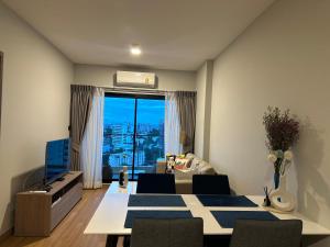 a living room with a dining room table with a view at Astra Sky River- Chiang Mai 1 in Chiang Mai