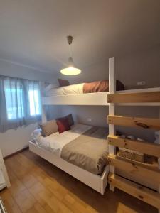 a bedroom with two bunk beds and a window at TERRAZA DEL VELETA junto a CARD in Sierra Nevada