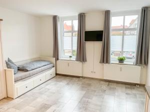 a living room with a couch and two windows at Alte Försterei 2.0 in Thale
