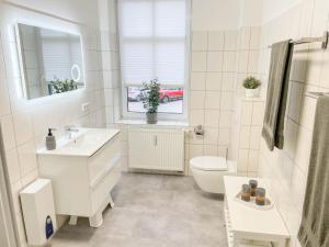 a bathroom with a sink and a toilet and a window at Alte Försterei 2.0 in Thale +6 photos