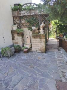 un jardín con un patio de piedra con una puerta y una estatua en Da NONNA ROSA Camera Nera, en Budrio