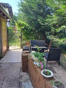 un patio con 2 sillas y flores y una valla en Da NONNA ROSA Camera Nera, en Budrio