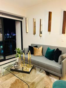 a living room with a couch and a glass table at Hermoso Departamento de Lujo cerca del Auditorio Telmex in Guadalajara