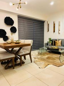 a living room with a wooden table and a dining room at Hermoso Departamento de Lujo cerca del Auditorio Telmex in Guadalajara