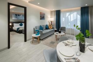 Citadines Al Ghubrah Muscat في مسقط: غرفة معيشة مع أريكة وسرير وطاولة