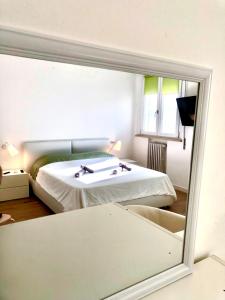 a reflection of a bedroom with a bed in a mirror at Stanza e idromassaggio, con extra fee, in delizioso appartamento in Ferrara