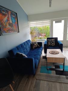 a living room with a blue couch and a table at Apartament przy Białym Koniu in Koszalin