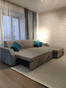 salon z kanapą i niebieskimi poduszkami w obiekcie Central Bishkek Apartment w mieście Biszkek