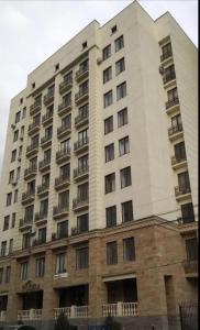 duży biały budynek z balkonem w obiekcie Central Bishkek Apartment w mieście Biszkek