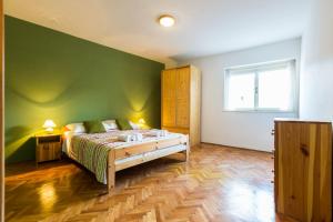 a bedroom with a bed and a green wall at Lavender apt. w. balcony in old town in Zadar
