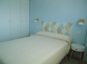 a bedroom with a white bed and a blue light at Siente el mar in Villajoyosa
